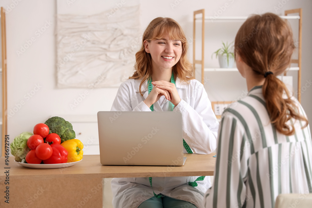 Female nutritionist working with patient at table in office