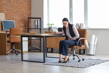 Canvas Print - Young businesswoman suffering from severe abdominal pain in office