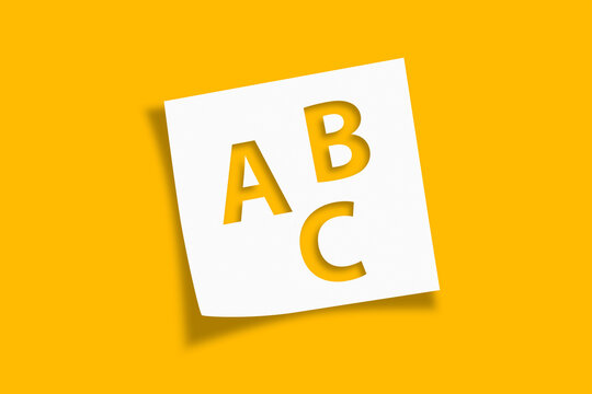 White note paper with Letters ABC on yellow background