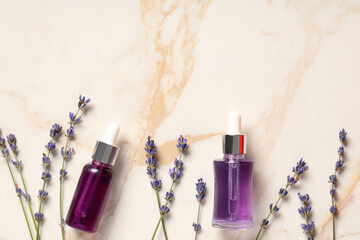 Wall Mural - Bottles of lavender essential oil and flowers on marble background