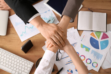 Poster - Business team putting hands together as symbol of unity during meeting in office, closeup