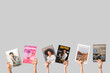 © Pixel-Shot - Female hands with different magazines on grey background