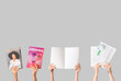 © Pixel-Shot - Female hands with different magazines and newspapers on grey background