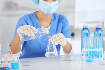 Poster - Female young scientist with professional glassware examining water quality in research laboratory