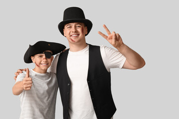 Wall Mural - Father with his son dressed for Halloween hugging on light background