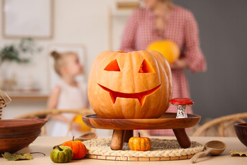 Sticker - Stand with carved Halloween pumpkin on table in room, closeup