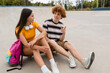 © InsideCreativeHouse - Couple of caucasian teenagers classmates students high school pupils friends boy girl in casual meeting talking have fun date spend time together weekend summer holidays in skate park sitting on ramp