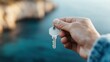 ©  Shomixer - A person holds a key up against a blurred oceanic background, representing the themes of opportunity, freedom, and the unknown, with a serene yet adventurous atmosphere.