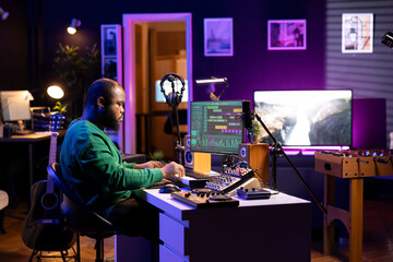Poster - Audio composer playing piano electronic keyboard to create a new track, adjusting volume levels on old recordings. Music producer recording sounds, plays tunes on midi controller.