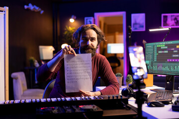 Poster - Talented artist explaining sheet with musical notes on smartphone vlog, doing online lessons in his home studio. Producer musician teaching people how to read music sheet, piano keyboard.