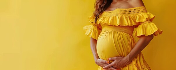 Canvas Print - Pregnant woman in a vibrant yellow sweater, lovingly cradling her belly, conveying warmth and love. Free copy space for banner.