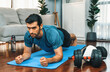 © Summit Art Creations - Athletic and sporty man doing plank on fitness mat during home body workout exercise session for fit physique and healthy sport lifestyle at home. Gaiety home exercise workout training.