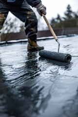 Poster - A man paints a roof using a roller