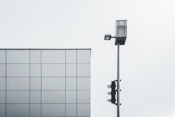 Poster - A city scene with a traffic light standing next to a tall building, great for urban or infrastructure illustrations