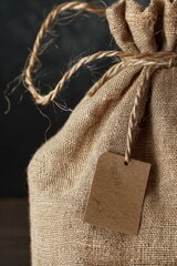 Poster - A bag with a tag on a wooden table, great for commercial use such as product display or presentation