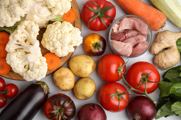 Canvas Print - Different vegetables and raw meat for stew on light grey table, flat lay