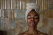 © LenaPolia - Skincare and beauty portrait. An African  woman with beautiful face in spa with a towel on her head. Young adult smiling girl model in sauna.