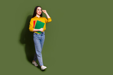 Canvas Print - Full length photo of cheerful pretty lady dressed yellow blouse holding book walking empty space isolated khaki color background