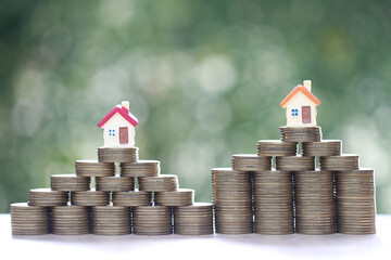 Wall Mural - Mortgage,Model house and stack of coins money on natural green background,Business investment and real estate concept