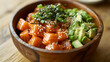 © Kraiwit - Rustic Presentation A rustic wooden bowl filled with a hearty salmon poke, including large cubes of salmon, avocado, seaweed, and a generous sprinkle of sesame seeds