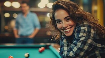 The attractive pool player is grinning and leaning on the billiard table, while the male player is in the background.