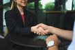 © Prathankarnpap - Confident businesswoman in suit shaking hands with her business partner