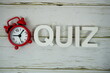 © may1985 - Quiz alphabet letters with alarm clock top view on wooden