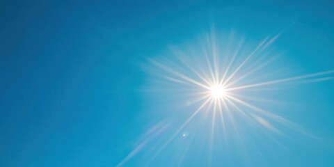 a bright sun shining in a clear blue sky with soft lens flare and no clouds.