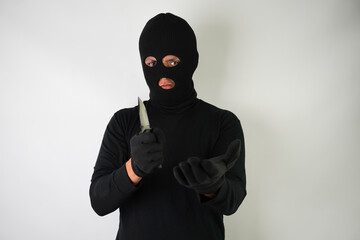 Wall Mural - Armed and Dangerous Young Adult black masked robber brandished a knife at the victim in an attempt to steal valuable items. 