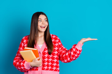 Sticker - Photo of clever woman dressed knitwear cardigan holding copybooks look at product on palm empty space isolated on blue color background