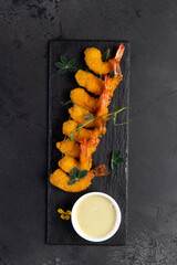 Wall Mural - Fried shrimp and sauce on a dark background.