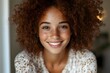 © Cavan - Freckled young woman with curly hair smiling brightly