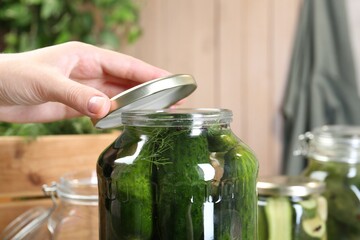 Wall Mural - Woman making pickled cucumbers at table, closeup