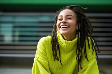 Dreadlocks laughing outdoors smiling.