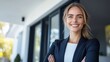 © cloud7days - Confident female agent smiling beside modern home entrance.