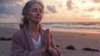 © Kiron - A fit and serene elderly woman practicing mindfulness with hands in namaste mudra on a peaceful beach at dawn. Ai generated