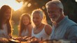 © Attasit - A multigenerational family gathering outdoors, with everyone participating in the evening barbecue.