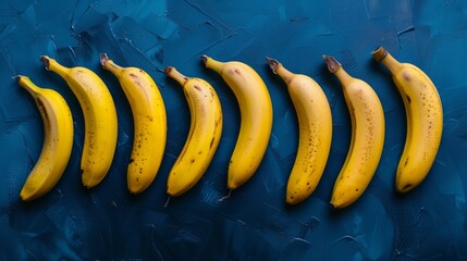 Poster - Bananas lying in a row on a dark blue background