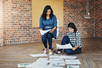 Meeting, collaboration and creative business women planning on floor, writing notes and discussion. Teamwork, documents and group working on strategy, project or report in office boardroom on ground