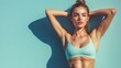 © Thavesak - Defined Six-Pack Abs of Young Woman on Pastel Blue Background - Fitness and Wellness Concept with High Contrast