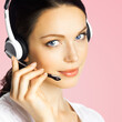 © vgstudio - Call center help line service ad concept - face portrait customer support sales operator in headset, isolated rose pink background. Brunette beautiful woman. Caller worker. Phone advisor. Square image