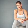 © peopleimages.com - Studio, portrait and woman with fitness ball, confident and training for core muscle and strength. Grey background, space and health of person with exercise for balance of body, smile and happy