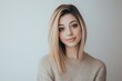 © neiros - Studio shot of good-looking beautiful woman isolated against blank studio wall. Nice smiling girl with fair hair and casual clothing, smiling at camera and being happy. Beautiful girl isolated