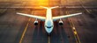 © Maksym - Airplane preparing for takeoff at the airport runway during sunset, showcasing a vibrant sky and airport surroundings