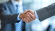 © Lakkhana - A businessman shaking hands in a corporate setting, sealing a deal