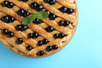 Sticker - Delicious homemade blueberry pie with mint on light blue background, top view