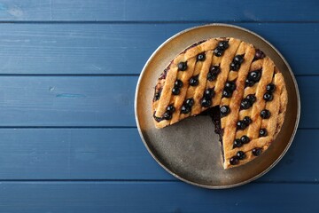 Wall Mural - Cut homemade blueberry pie on blue wooden table, top view. Space for text