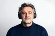© Downloads - Closeup Portrait of Thoughtful Middle aged Caucasian Man Wearing Headphones Against White Studio Background 3D Rendering