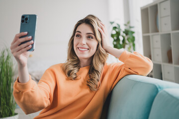 Canvas Print - Portrait of nice young girl sit couch take selfie photo wear orange clothes modern interior flat indoors