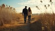 © fotofabrika - A couple walking hand in hand through a golden field at sunset, enjoying a peaceful moment in nature together